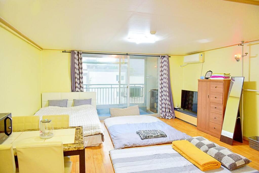 Zimmer mit 2 Betten, einem Tisch und einem TV in der Unterkunft G-503 Secret AZIT in Gunsan in Gunsan