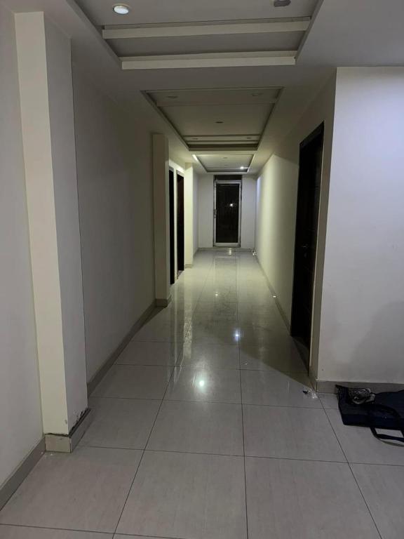 an empty hallway with white walls and a tile floor at Com Heights Near Clock chowk bahria Town Lahore in Rāmkot
