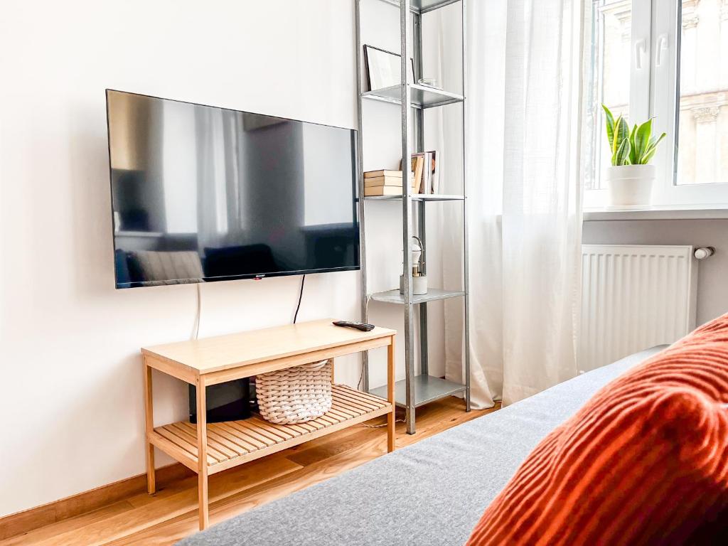 a bedroom with a tv on a wall at Polpo Apartments - Nawrot 50 in Łódź