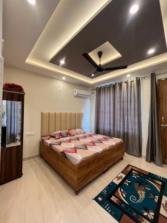 a bedroom with a bed and a ceiling at Anjali Home Stay in Rishīkesh