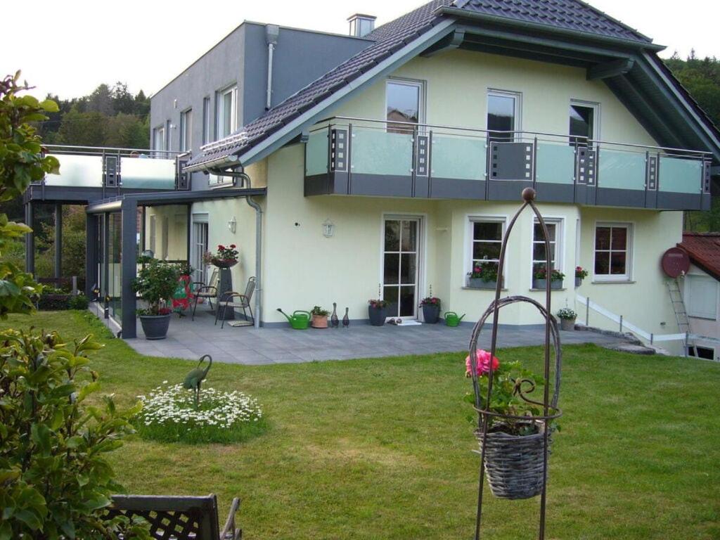 a house with a yard with a bird feeder at Luise Bernhardt Modern retreat in Poppenhausen