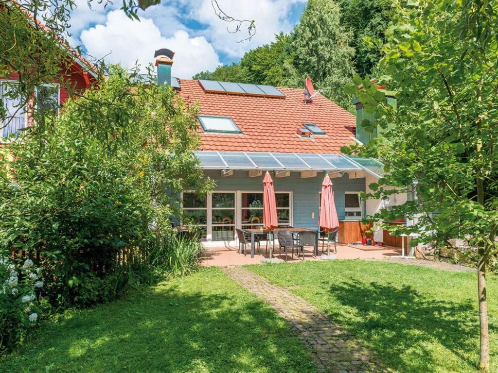 ein Haus mit einer Terrasse und einem Tisch mit Sonnenschirmen in der Unterkunft am Schönwasen Modern retreat in Freiamt