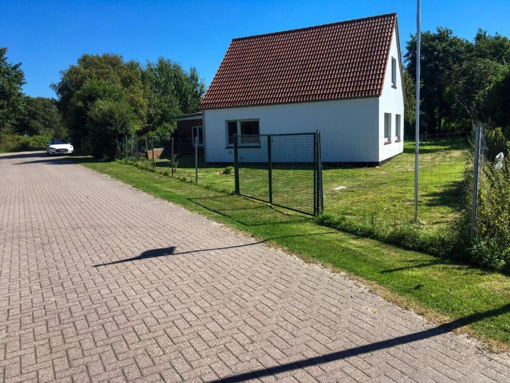 uma casa com uma cerca ao lado de uma estrada de tijolos em Borkum Freedom 2 em Borkum