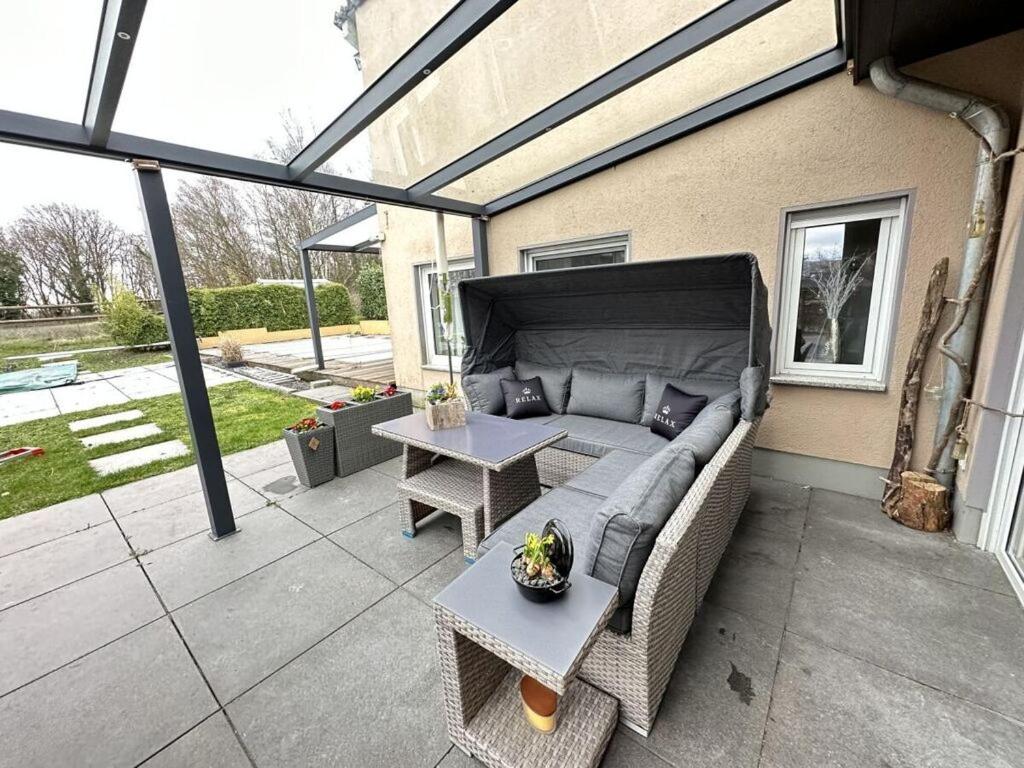 a patio with a couch and a table at Milan Modern Retreat in Xanten