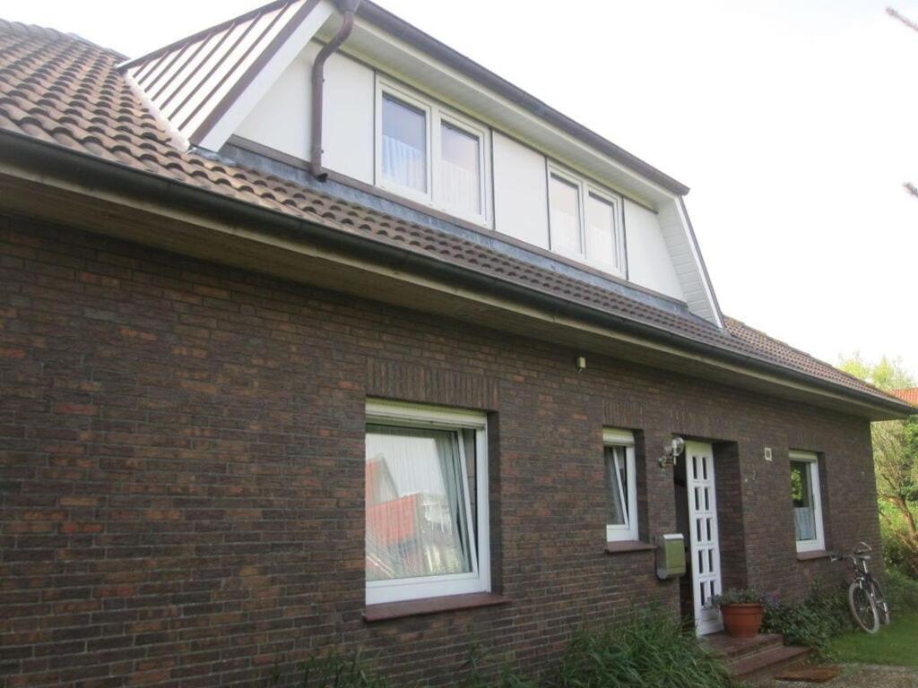 a brick house with windows and a roof at Holiday home Fischer in Juist