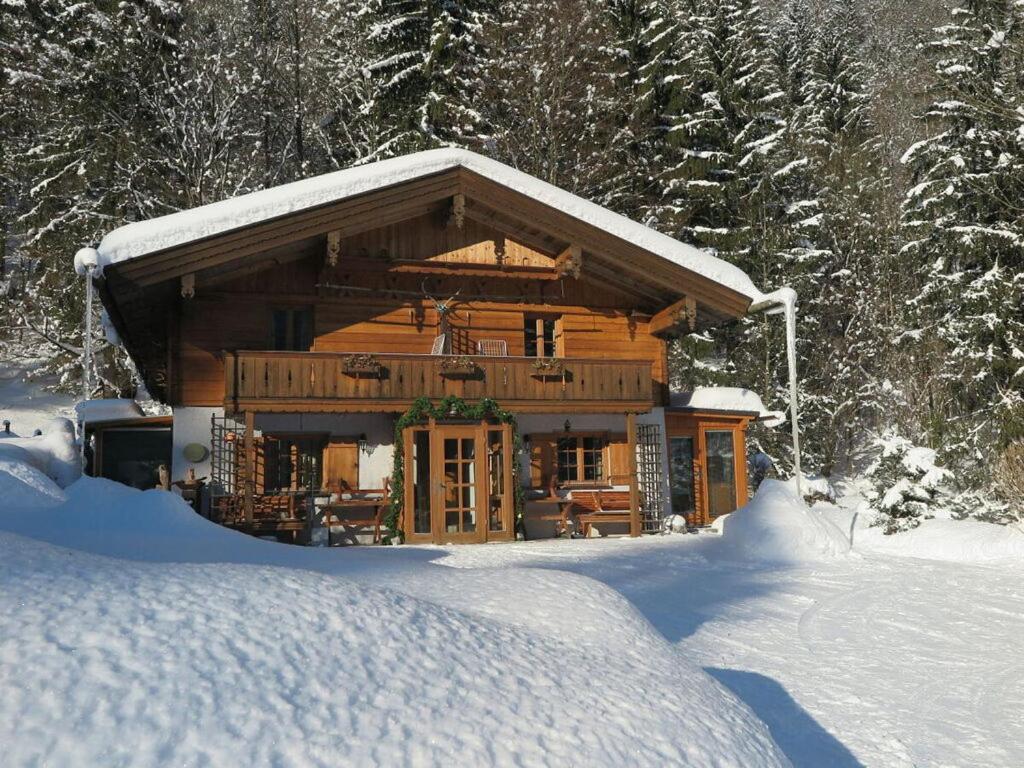 a large log cabin with snow on the roof at Nagelsmederij in het huis Waldwinkel in Aschau im Chiemgau