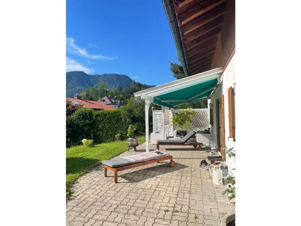 a patio with a bench and a umbrella at Chalet Salzeder Modern retreat in Bayerisch Gmain