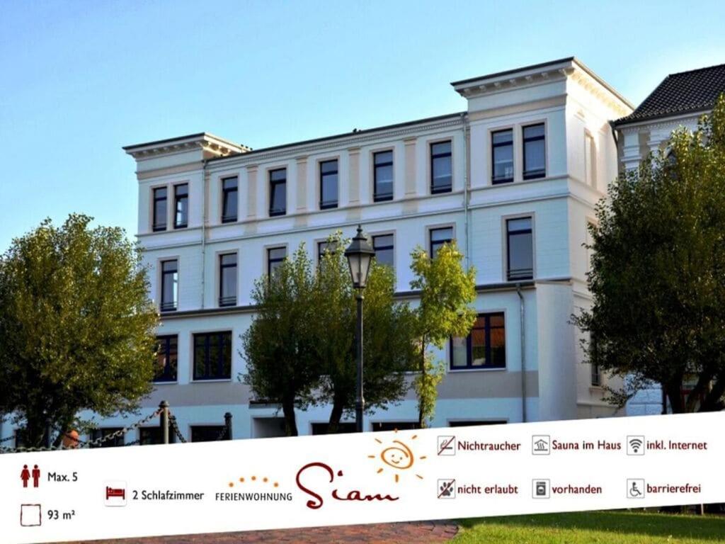 a white building with a banner in front of it at Siam Comfortable Holiday Residence in Borkum
