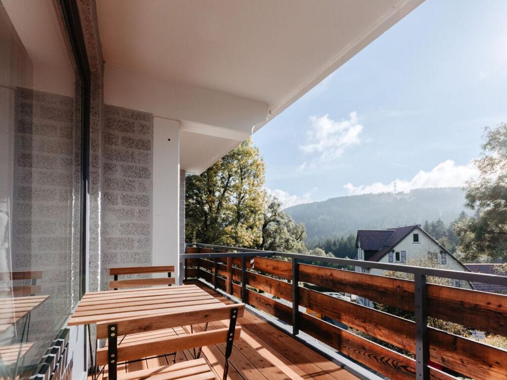 a balcony with a wooden table and a view at Granetal Quarter apartment Bocksberg in Goslar