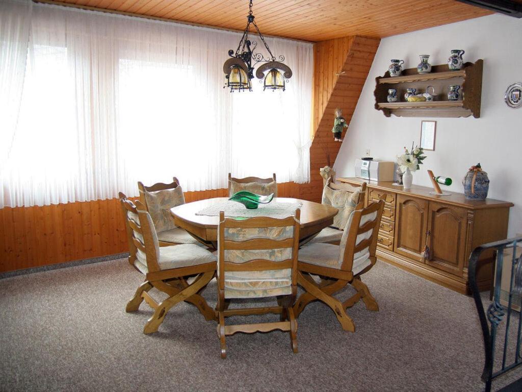 comedor con mesa de madera y sillas en Brown Modern Retreat, en Sankt Aldegund