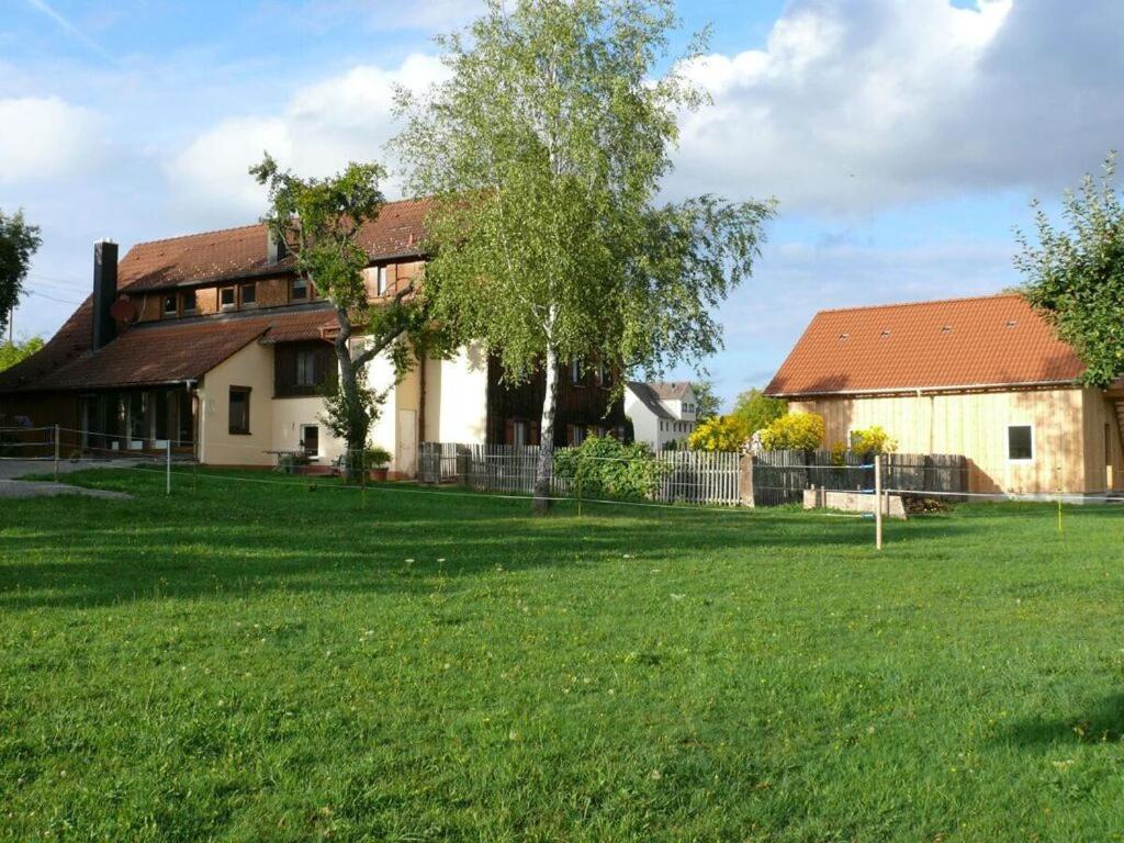 una casa con un campo verde delante de ella en 1 Fuchskreuzhof Modern retreat, en Simmersfeld