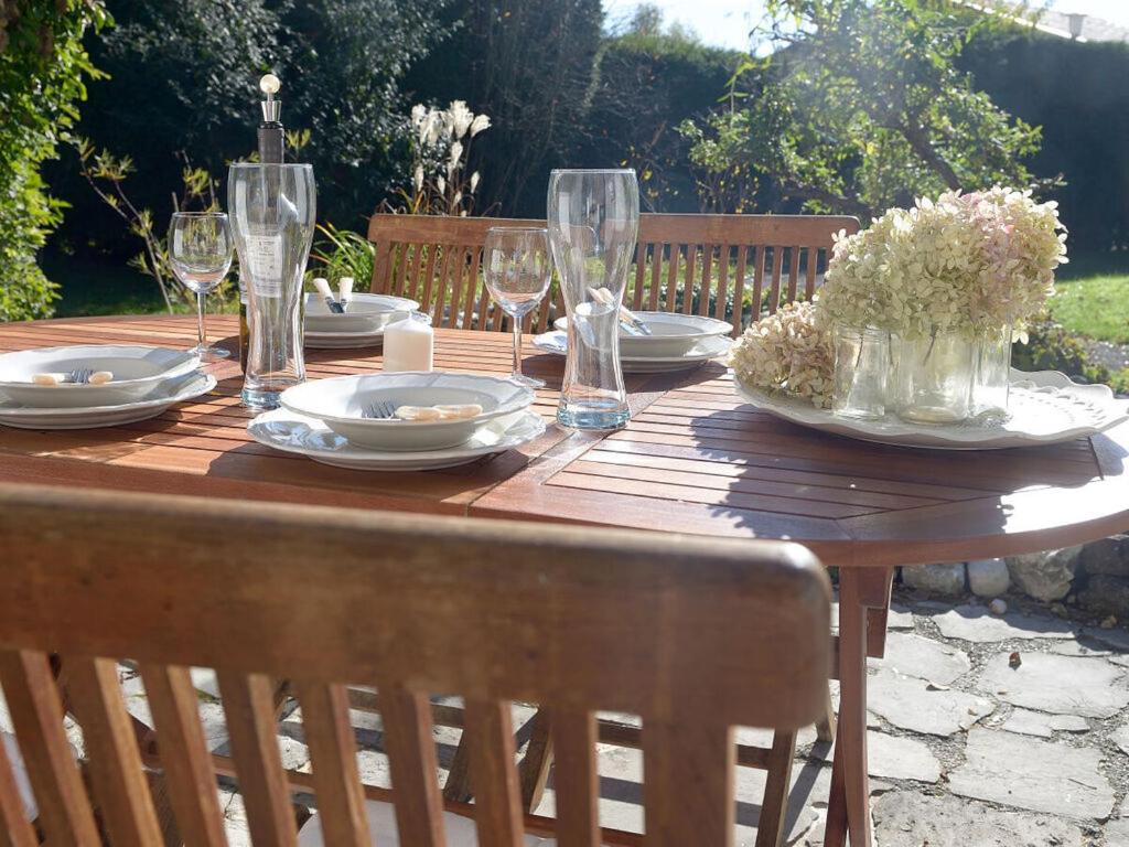 una mesa de madera con platos y copas de vino. en Holiday apartment at Molopark, en Murnau am Staffelsee