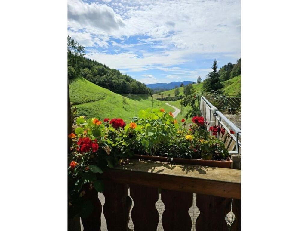 a view of a valley from a balcony with flowers at Eisenmann holiday farm in Gengenbach