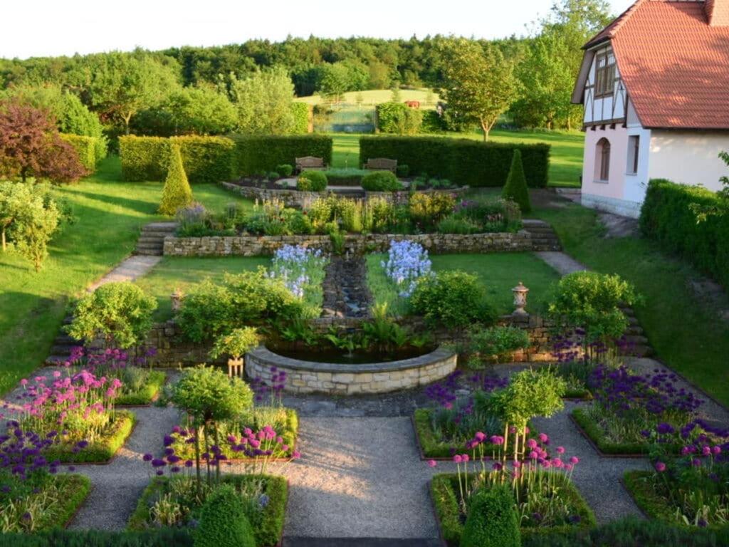 un jardín con flores y un edificio de fondo en Villa Taubenberg, en Rinteln