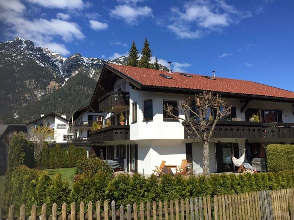 Biały dom z czerwonym dachem z płotem w obiekcie Valley station Modern retreat w Garmisch Partenkirchen