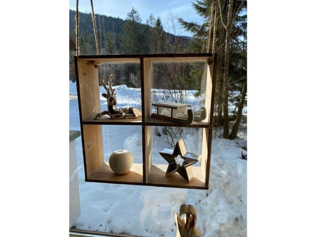 une photo d'une fenêtre avec quelques objets dans la neige dans l'établissement Bergglück Modern retreat, à Reit im Winkl