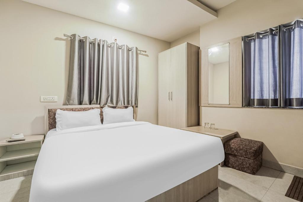 a bedroom with a large white bed and a chair at Super OYO Hotel Rameshwar in Rānchī