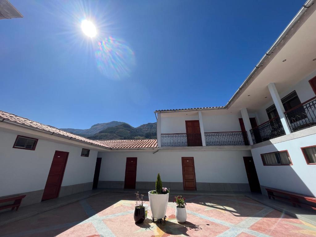 a view of a building with the sun in the sky at Hotel Restaurante Minas Cocha in Chavín de Huantar