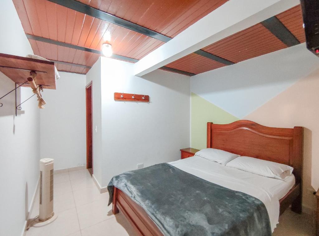 1 dormitorio con cama y techo de madera en La Rosa Náutica Club, en Guaduas