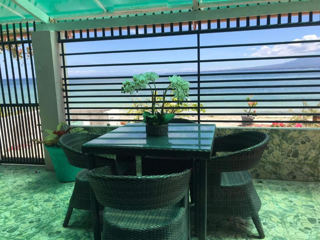 una mesa con sillas de mimbre frente a una ventana en Joy O Hoy Beach House, en Santander