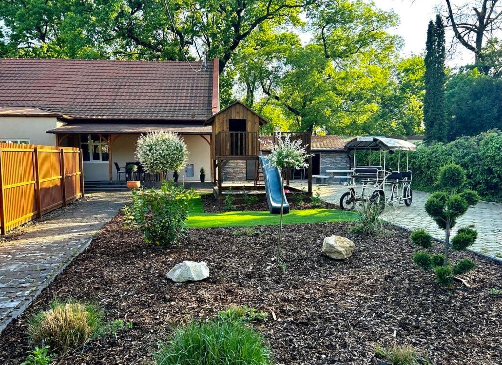 un jardín con parque infantil y una casa en Éden Vendégház Gyula, en Gyula