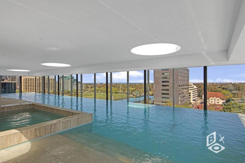 a large swimming pool in a building with windows at Rest 1 BedRooms Fawkner APT in Melbourne