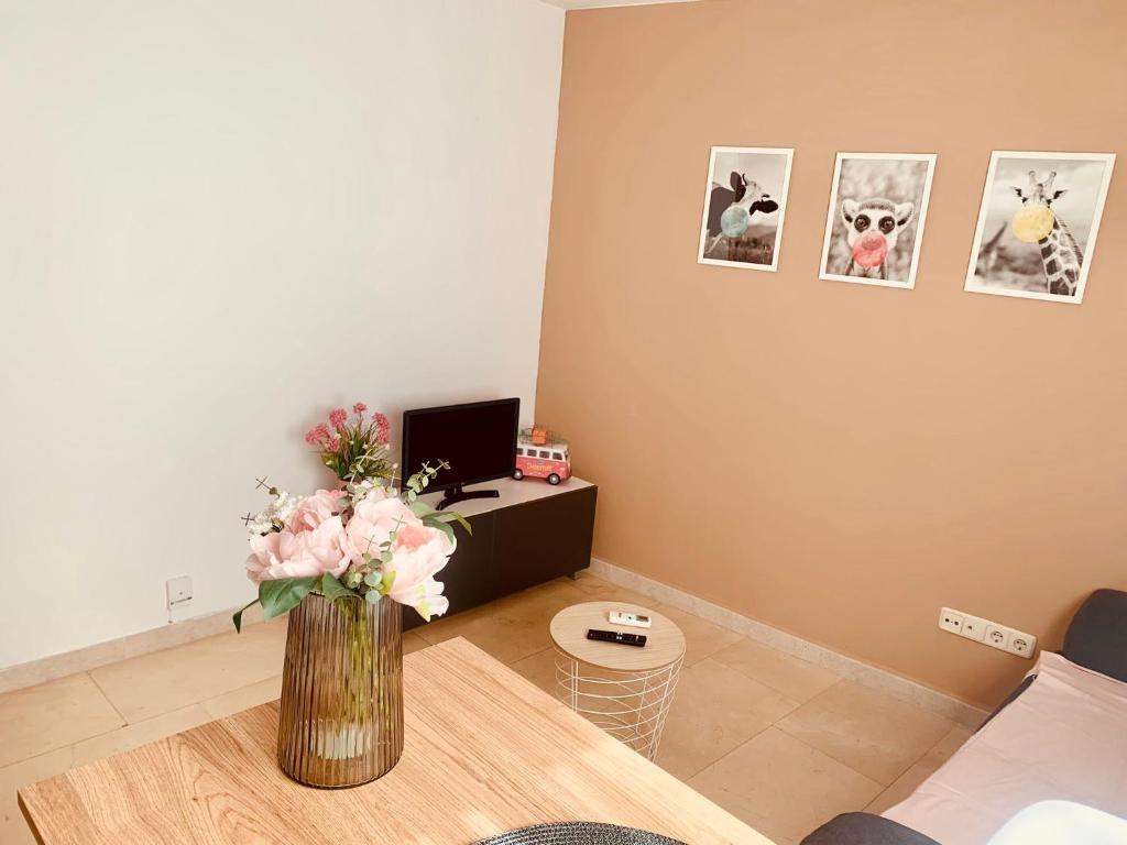a living room with a vase of flowers on a table at APARTAMENTO 2p MENDIVIL MADRID CENTRO in Madrid