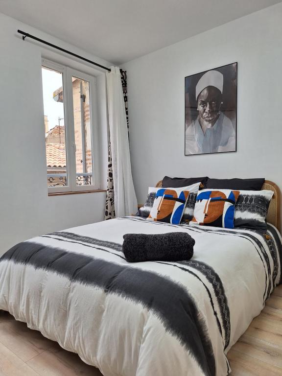 a bedroom with a bed with a black and white comforter at Chambre NINA in Agen
