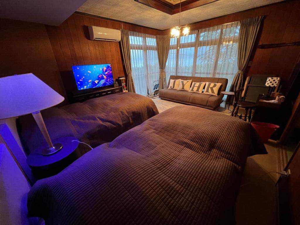 1 Schlafzimmer mit 2 Betten und einem Flachbild-TV in der Unterkunft Iojima BeachHouse - Vacation STAY 97622v in Nagasaki