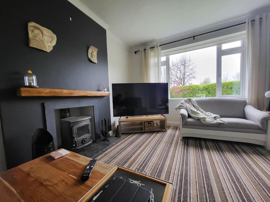 a living room with a couch and a television at Carrigaline Delightful Home in Carrigaline