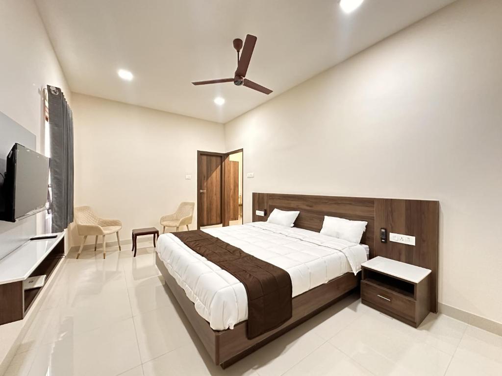 Schlafzimmer mit einem Bett und einem Deckenventilator in der Unterkunft TULIP HOMES in Coimbatore