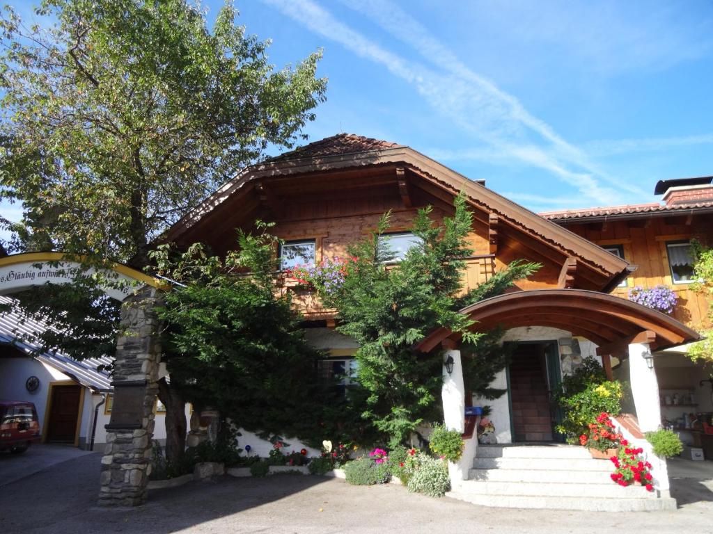 una casa con scale e fiori di fronte di Bio-Bauernhof Simonbauer a Ramsau am Dachstein