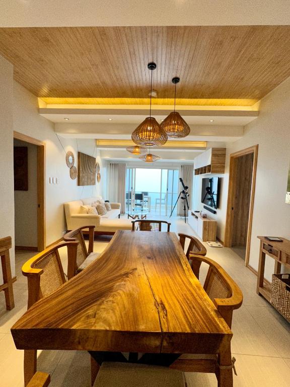 uma grande mesa de madeira numa sala de estar com um sofá em 2 BR Lime Penthouse, Tagaytay Highlands em Tagaytay