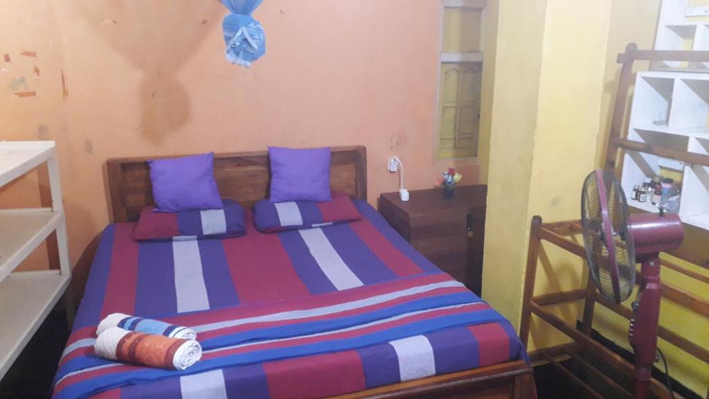 a bedroom with a colorful bed with blue pillows at Shalom View Homestay in Kandy