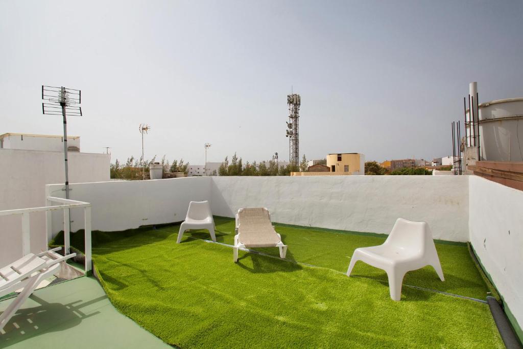 deux chaises sur un toit avec de l'herbe verte dans l'établissement Atico vecindario, aeropuerto, à Cruce de Arinaga