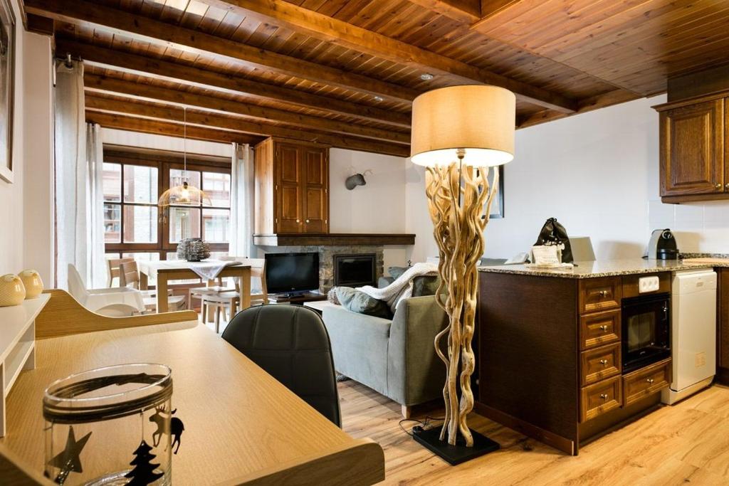 une cuisine et un salon avec une table et un canapé dans l'établissement Luderna - Apartamento Val de Ruda A2 Comalada, à Baqueira-Beret