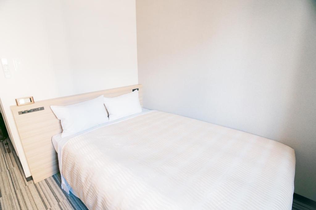 Postel nebo postele na pokoji v ubytování Quintessa Hotel Chiba Funabashi