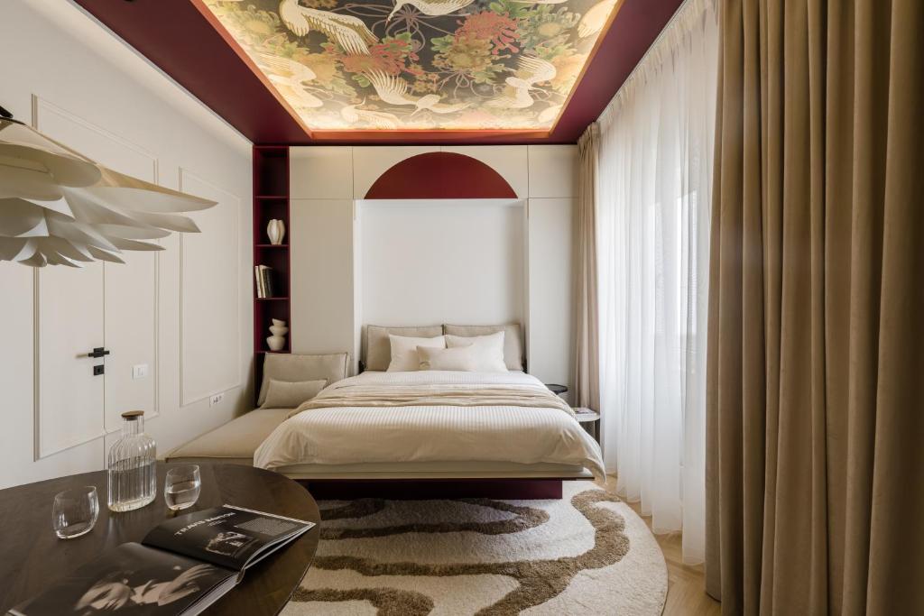 a bedroom with a bed with a painting on the ceiling at ROUGE Studio in Bucharest in Bucharest