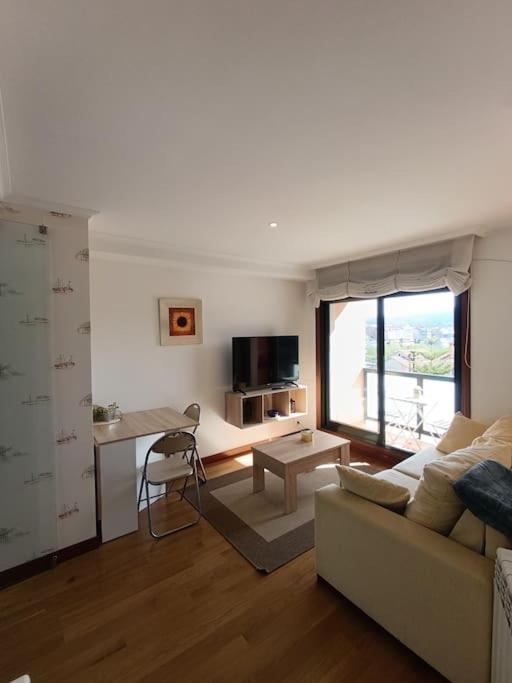 uma sala de estar com um sofá e uma mesa em Apartamento en Poio-Pontevedra em Poio