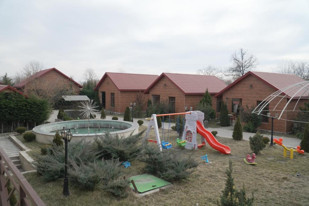 patio trasero con parque infantil con piscina y tobogán en Etci hotel & restaurant, en Gabala