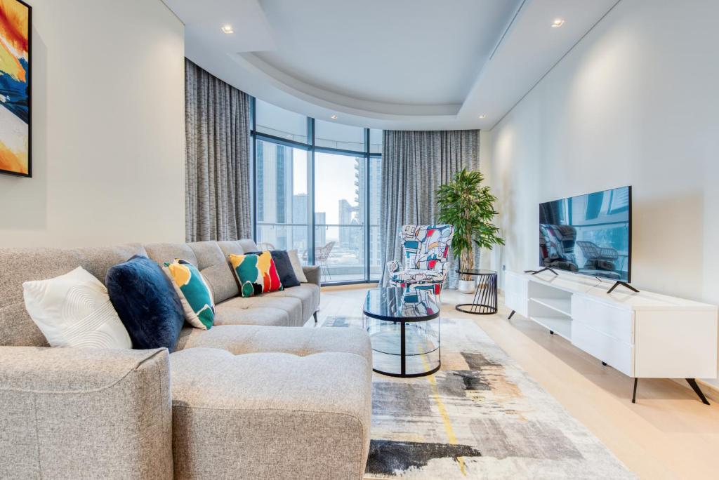 a living room with a couch and a tv at RH- Downtown Delight, spacious 01BR near Dubai Mall & Burj Khalifa, RP Heights in Dubai