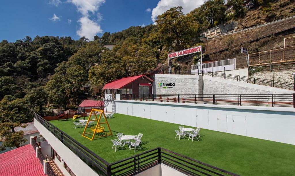 a field of grass with a playground on top of a building at Treebo Trend Stotrak S N Residency - Mussoorie in Mussoorie