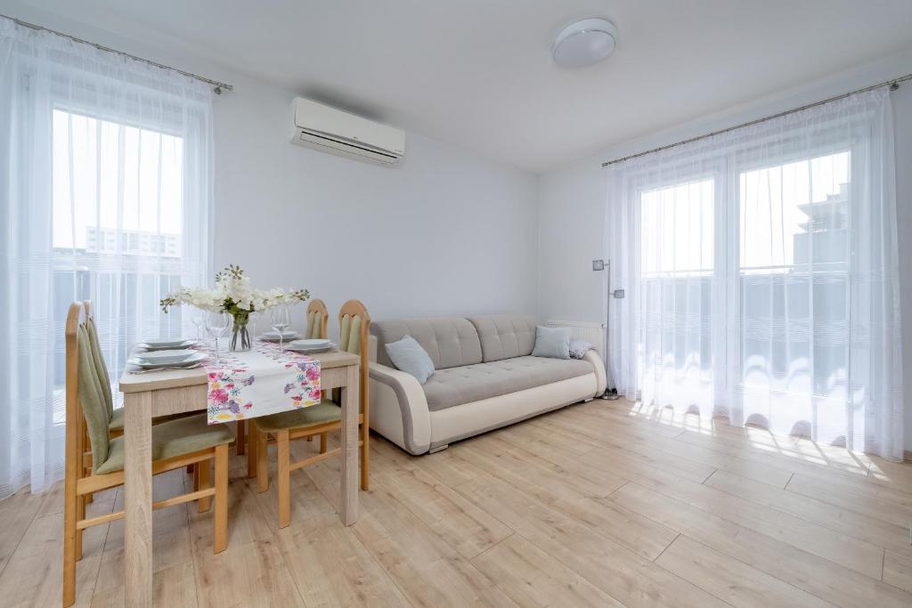 a living room with a couch and a table at Beautiful Apartment with a Spacious Balcony in Wrocław by Renters in Wrocław