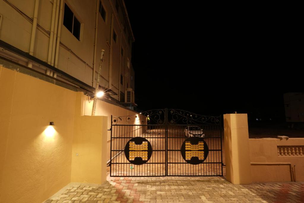 a gate with a sign on it next to a building at night at Hajiyar Residency in Rāmanāthapuram