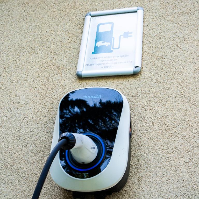 a smart phone with a hair dryer next to a book at The Hotel Unforgettable - Hotel Tiliana by Homoky Hotels & Spa in Budapest