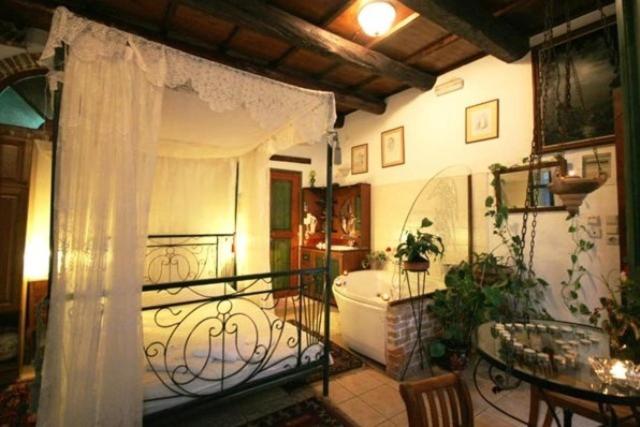 a room with a balcony with a tub and a table at Ifigenia Traditional Rooms & Maisonettes in Chania
