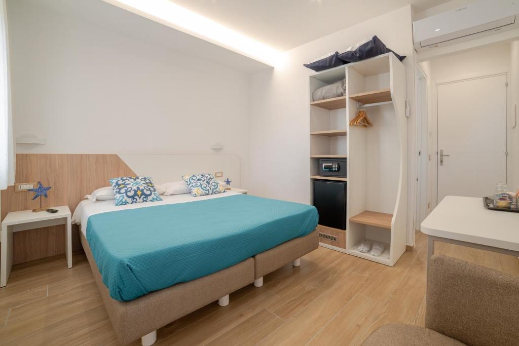 馬奧萊的住宿－Brezza Marina，一间卧室配有一张带蓝色床单的床和一张桌子。