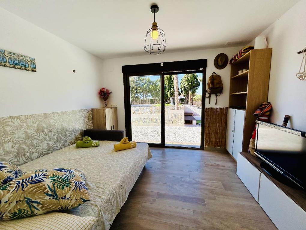 Habitación con cama y puerta corredera de cristal en Rancho Tropicana en Elche