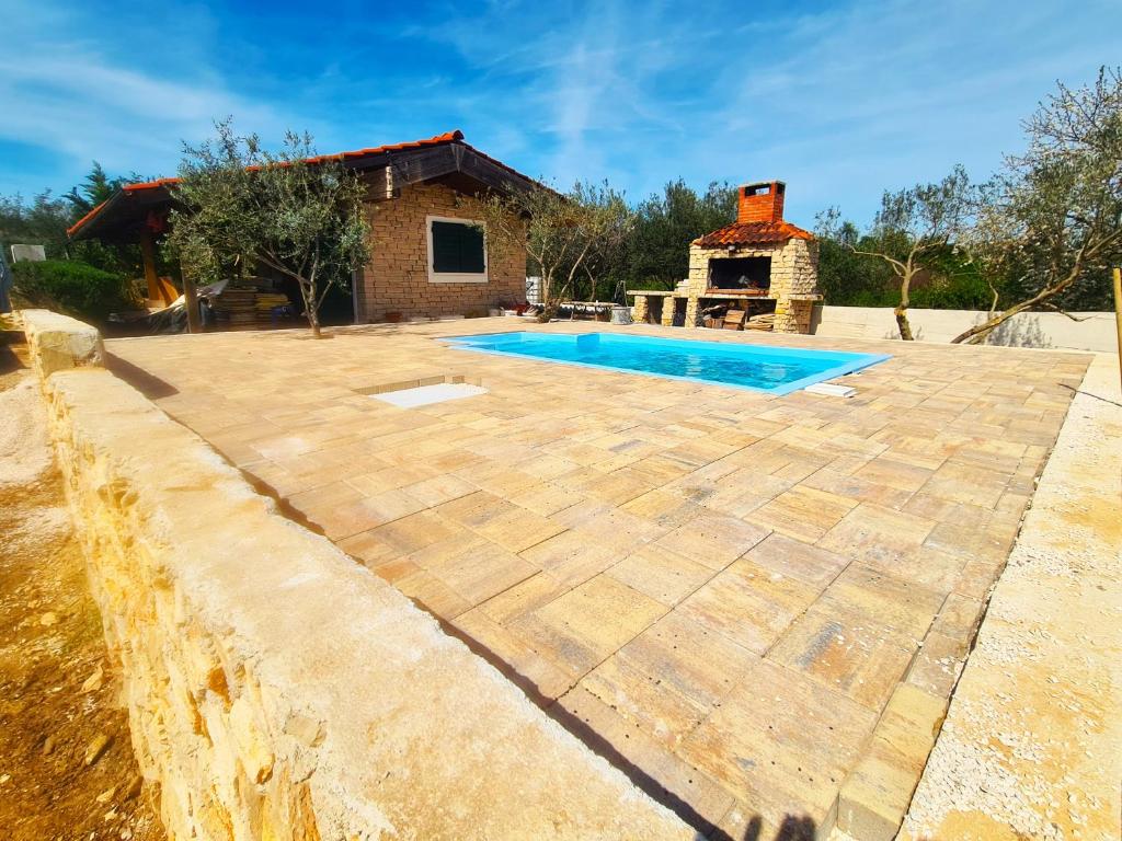 a patio with a swimming pool and a house at Romantic Villa Cherry in Zadar