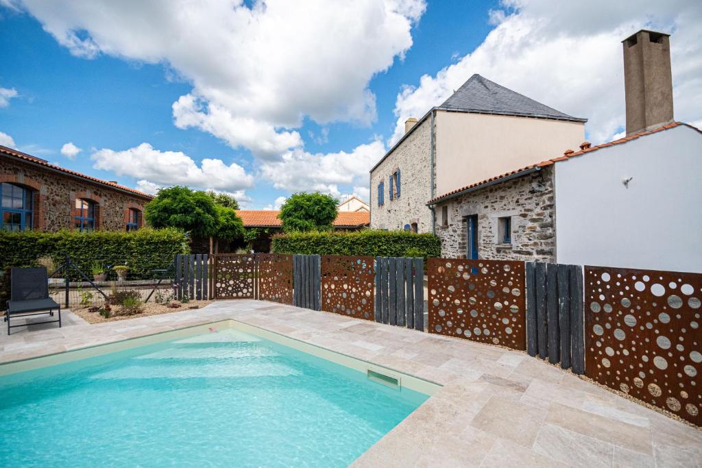 a swimming pool in the backyard of a house at Le DOMAINE DES ECOLIERS B&B in Montaigu-Vendée